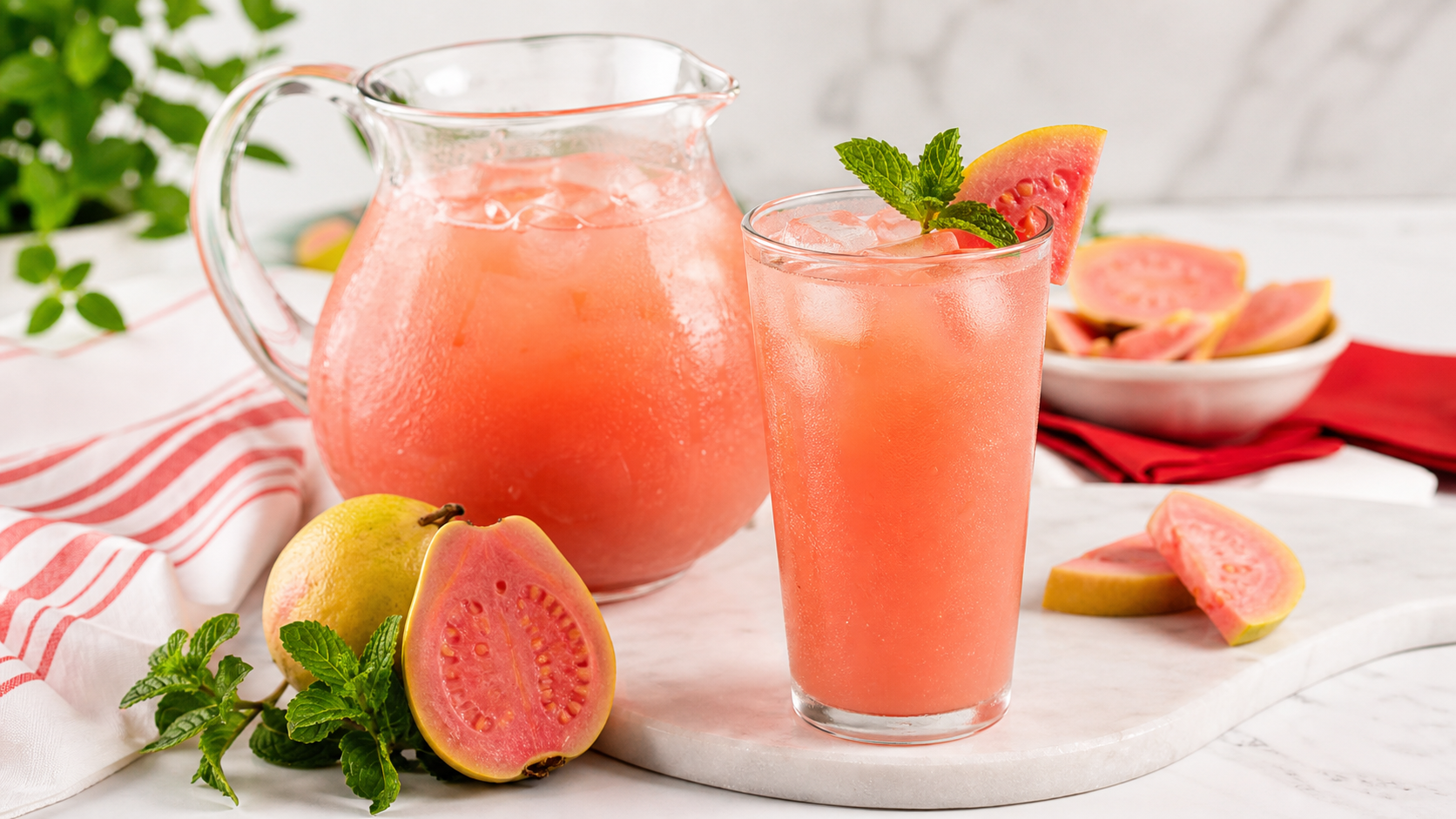Agua fresca de Guayaba rosa con pulpa Pulpamia servida en vaso y jarra